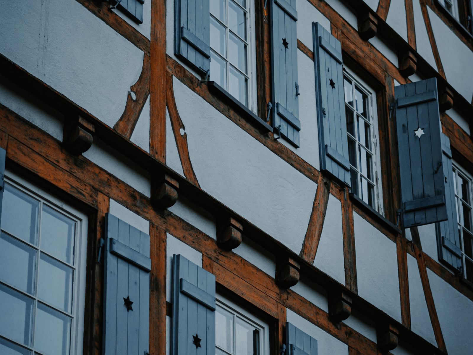Fachwerkfassade mit sichtbaren Holzbalken und Fensterläden